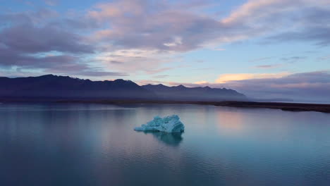 iceberg in a calm icelandic lake at sunset