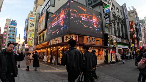 pedestrians walking through a neon-lit cityscape