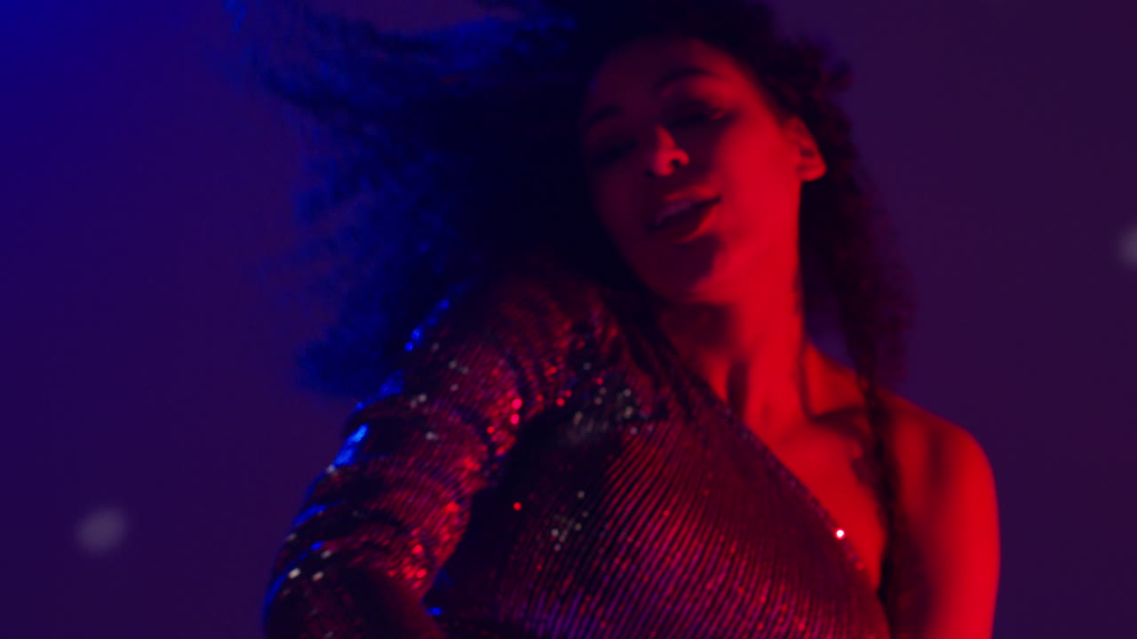 primer plano de una mujer joven en un bar de club nocturno o discoteca bailando con luces brillantes 13