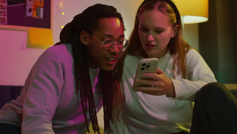 una pareja feliz mirando el teléfono.