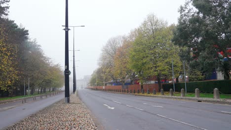 Empty-road-on-a-foggy-day-near-Cardiff-City-Hall,-there-is-an-amusement-park-to-the-right