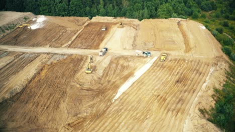 Aerial-top-down-view-of-an-excavator-loading-crushed-stone-into-a-dump-truck-in-a-crushed-stone-quarry