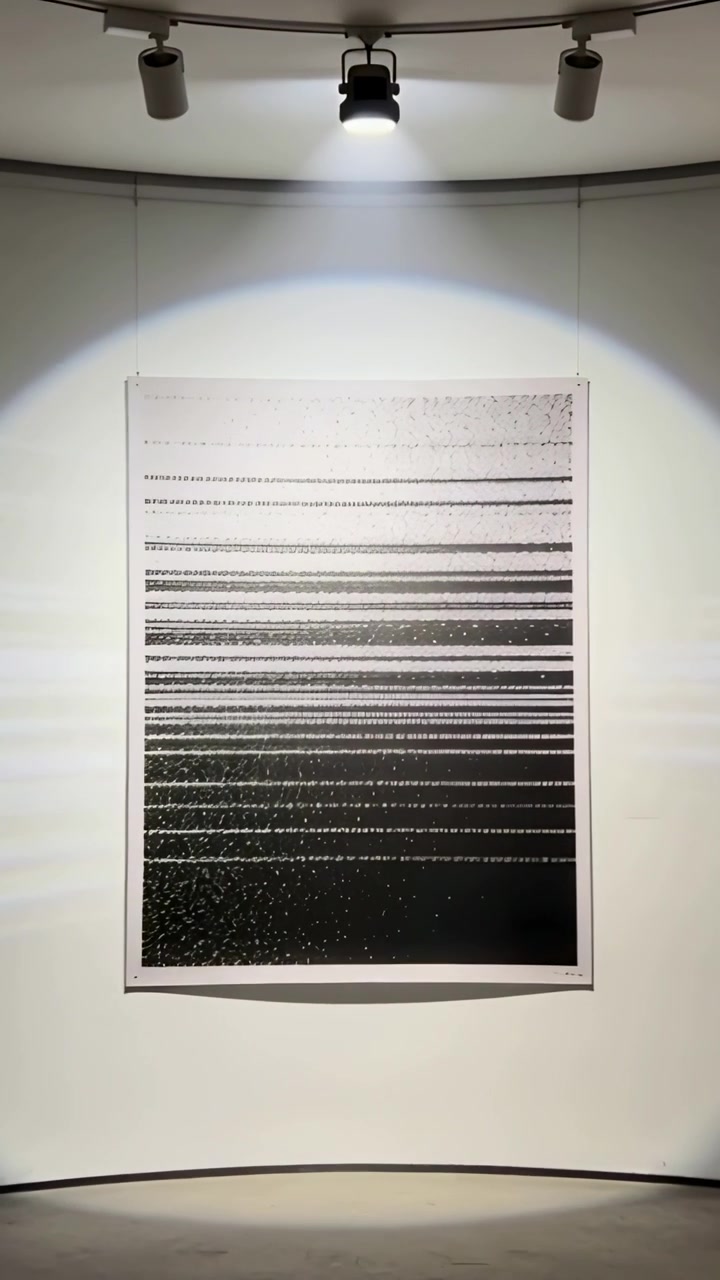 Vertical video: Moving camera approaching framed print on gallery wall, spotlight revealing texture