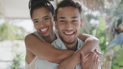 Portrait-of-happy-diverse-couple-embracing-on-porch-of-beach-house,-in-slow-motion