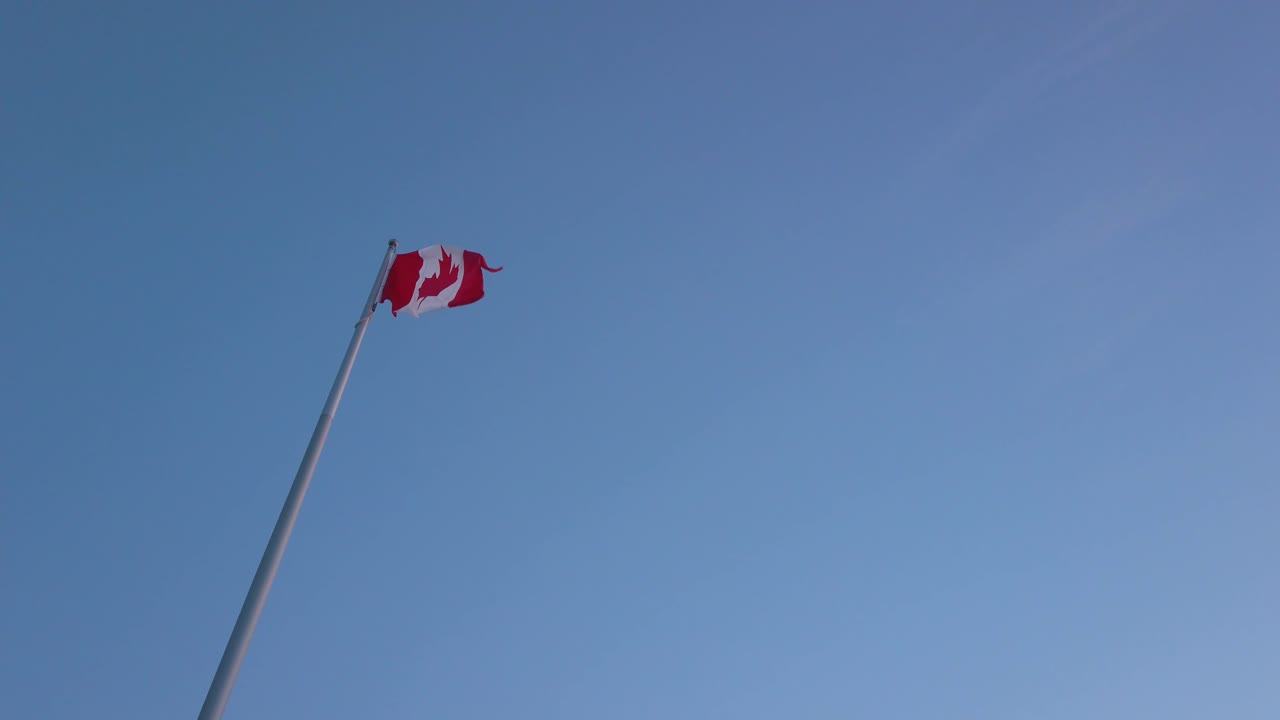 Slowmotion view landscape zooming view into the Canada's flag while wind blowing in sunset sky time