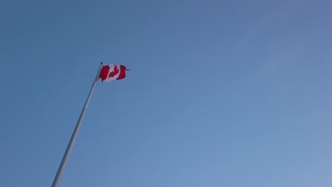 slowmotion view landscape zooming view into the canada's flag while wind blowing in sunset sky time