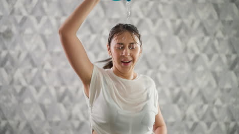 여성은 머리 위에 물을 부어 냉각합니다. 행복한 여성은 과열을 관리하여 최적의 성능을 유지합니다. 트레드밀 운동 중에 피로와 싸니다.