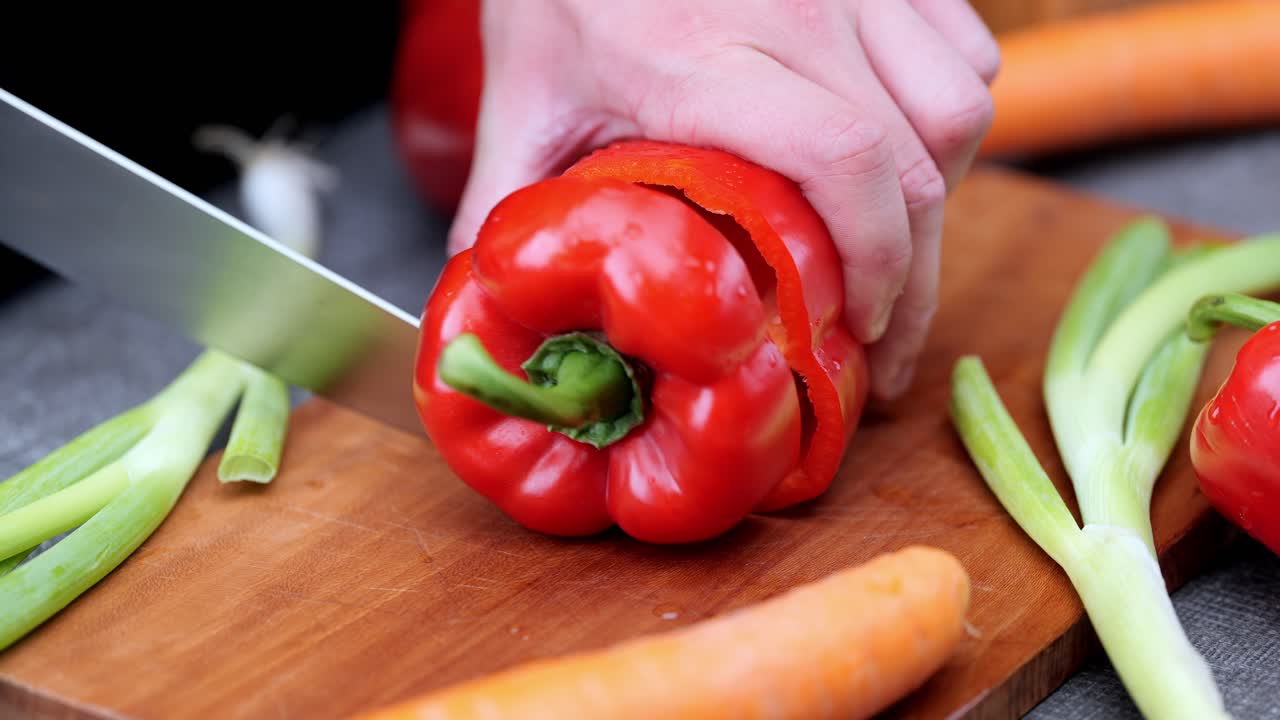 pimientos frescos cortados por el cocinero en una tabla de cortar de madera