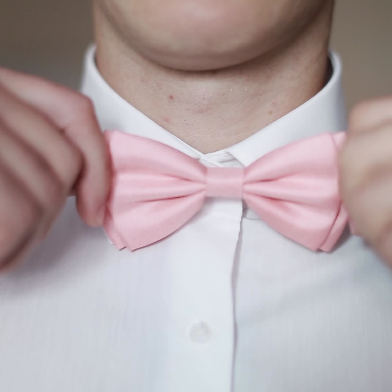 Man Puts On A Bow Tie