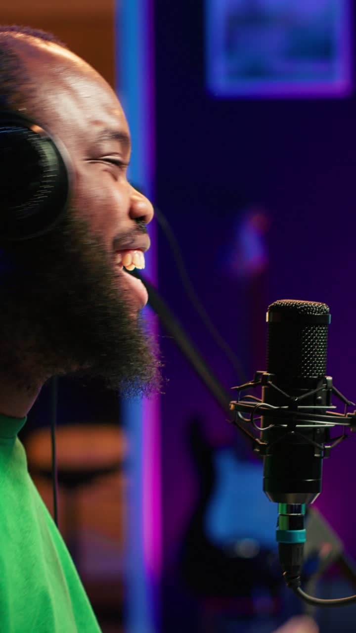 Glad afroamerikansk mand optager podcast i musikstudie