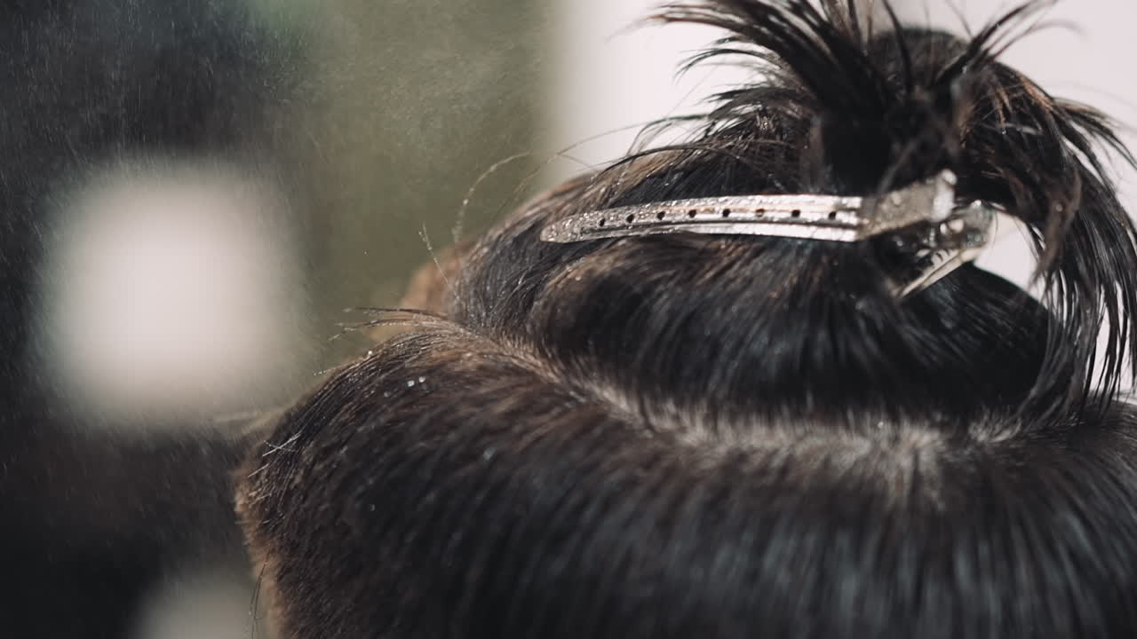 살롱에서의 절차에서 남성 클라이언트의 머리카락에 물을 뿌리는 것