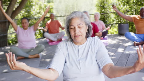 Fröhliche,-Vielfältige-Senior-Lehrerin-Und-Freunde-Praktizieren-Yoga-Meditation-In-Der-Sonne,-Zeitlupe