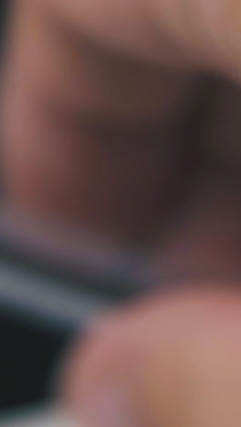 mature person holds modern ball pen in transparent case on dark blurred background extreme close view