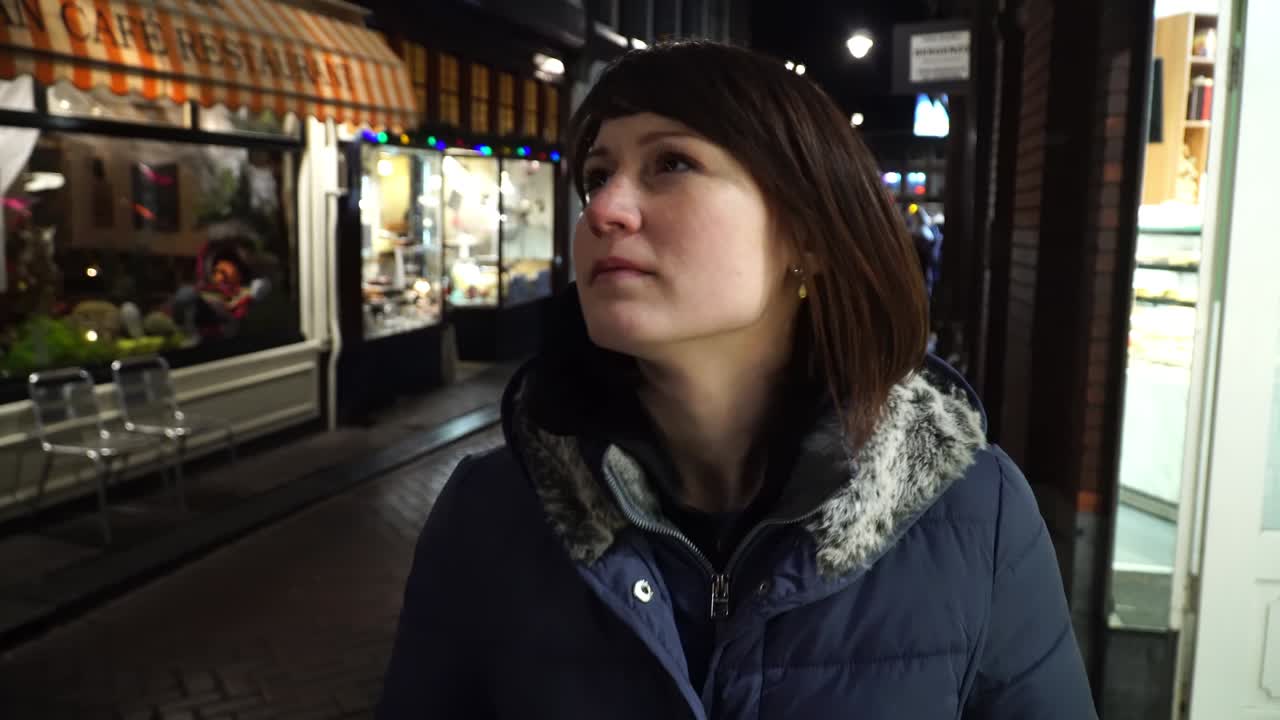 una chica turista camina por la noche en ámsterdam.