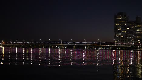 puente iluminado que se refleja en el agua tranquila