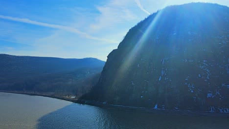 aerial drone footage of the appalachian mountains over a river valley in new york in the hudson river valley looking at storm king mountain in early spring