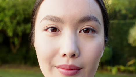 smiling woman looking at camera, close-up portrait in outdoor setting