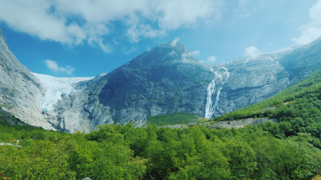 얼음이 있는 산을 배경으로 빙하의 물에서 나오는 아름다운 폭포는