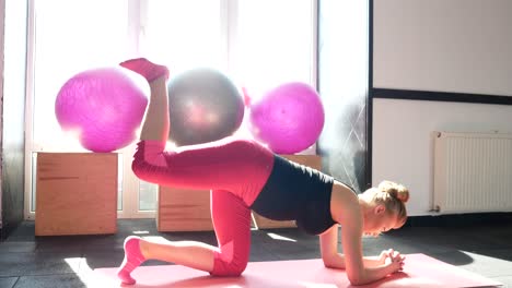 young pregnant woman doing exercises on a fitness ball at home young pregnant woman doing exercises on a fitness ball in her cozy living room promoting relaxation and wellbeing during pregnancy