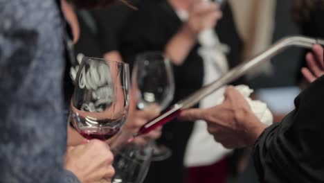 pouring wine sample from a barrel into a wine glass