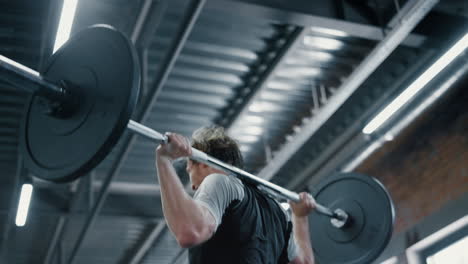 aggressive fighter doing workout in sport club. kickboxer lifting weight at gym