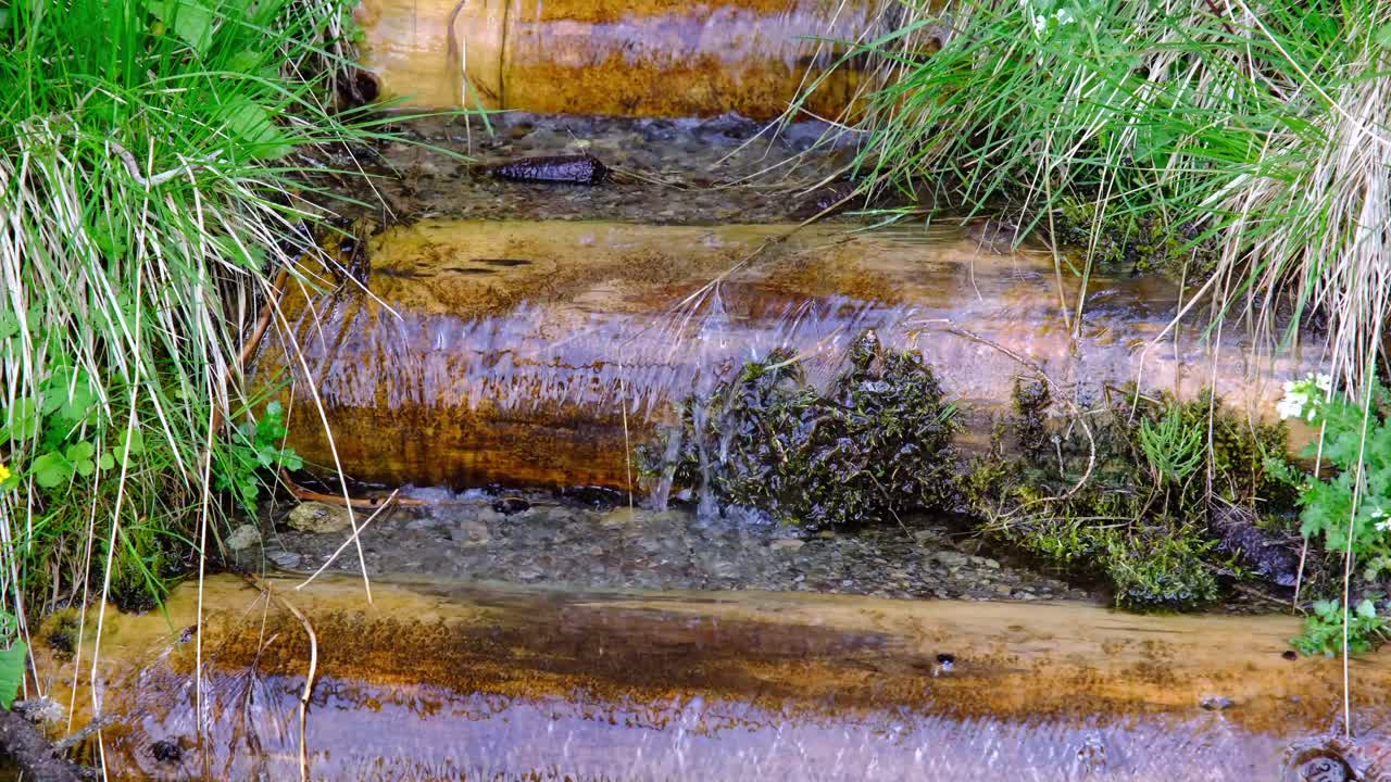 agua clara de los arroyos de la montaña en un camino hecho por el hombre para que la gente obtenga agua para beber