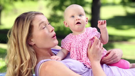 Happy-mother-playing-with-her-baby-girl-in-the-park