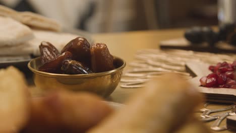 nahaufnahme einer schüssel mit datteln auf dem tisch der muslimischen familie zu hause, der für die mahlzeit zur feier von eid gedeckt ist