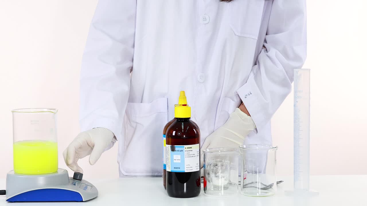 과학자는 실험실 환경에서 요오드 시계 화학 반응 실험을 시연합니다.