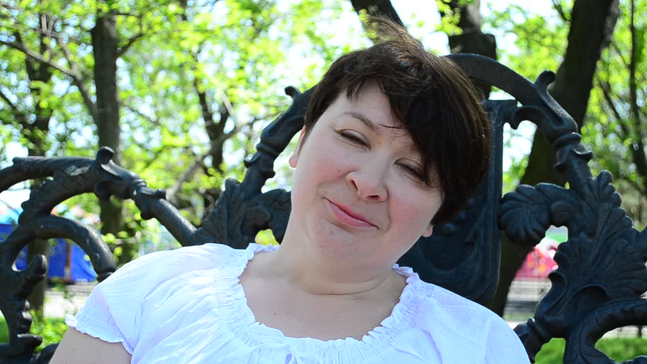 Menina sentada no parque. Mulher conversando e sorrindo