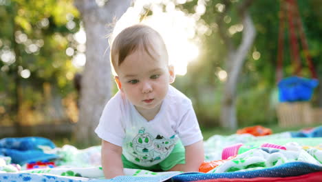 sweet caucasian kid playing on the plaid outdoors. lovely child looking into camera swaying. backdrop in blur.