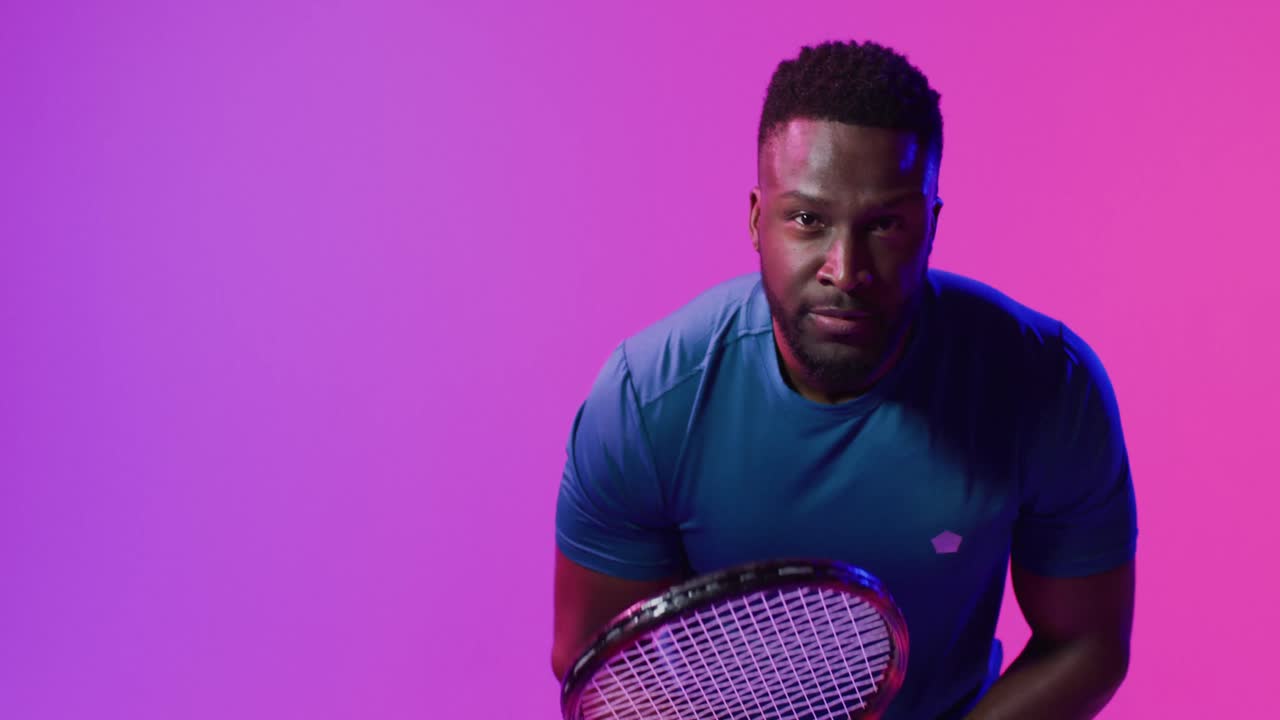 video de un jugador de tenis afroamericano enfocado en relámpagos rosados de neón