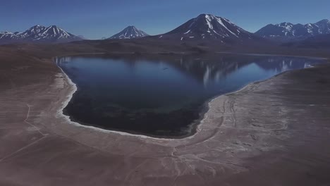 Lake-Meniques-on-Los-Flamencos-National-Reserve-and-Chile-volcanos-in-the-background,-Antofagasta-Region,-Bolivia