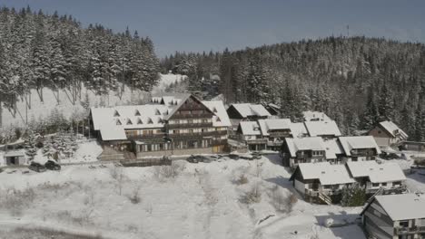 lukov dom winter resort with cabins in the pohorje mountains slovenia, aerial dolly out reveal shot