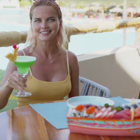 cheerful woman with cocktail resting in cafe