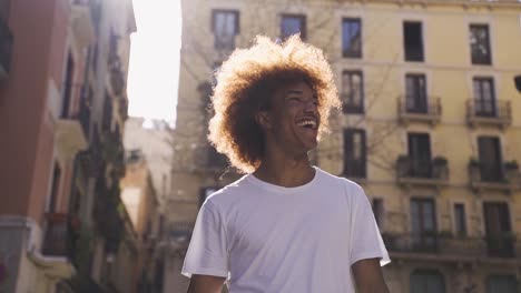 hombre negro positivo caminando por la calle de la ciudad con una sonrisa dentada