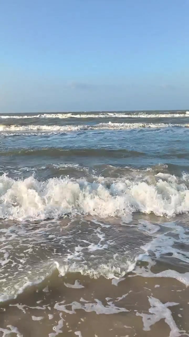 Dolci onde dell'oceano che si infrangono su una spiaggia sabbiosa.
