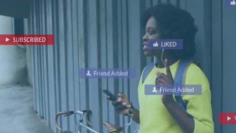 animation of social media notifications over happy african american woman using smartphone in street