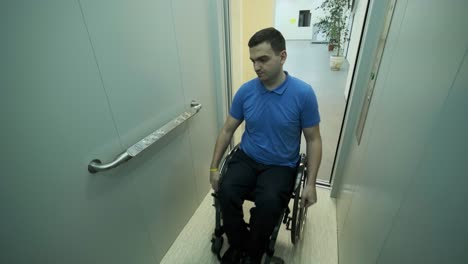 un hombre en silla de ruedas entra en el ascensor. una persona con discapacidad viaja en un ascensor.
