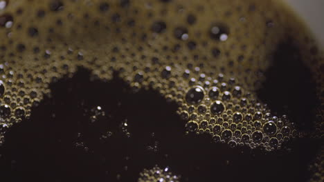 close up macro of coffee bubbles as mug is filled up