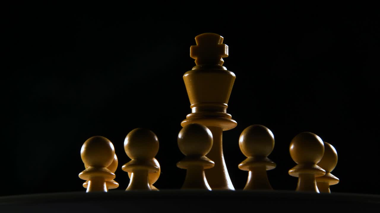 toma cinematográfica de una pieza blanca de ajedrez con los peones que la rodean