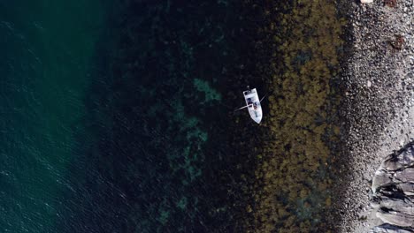 persona en bote rema en aguas cristalinas frente a la costa en vikan, indre fosen, noruega