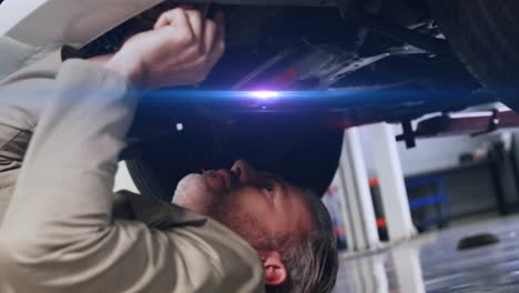 animation of light trails over caucasian male mechanic reapiring car