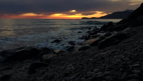 Puesta-De-Sol-De-Verano-Y-Tarde-En-La-Costa-Del-Mar-Jónico,-Cielo-Amarillo-Anaranjado-Y-Nubes-Oscuras-Colgando-Sobre-El-Paisaje-Marino