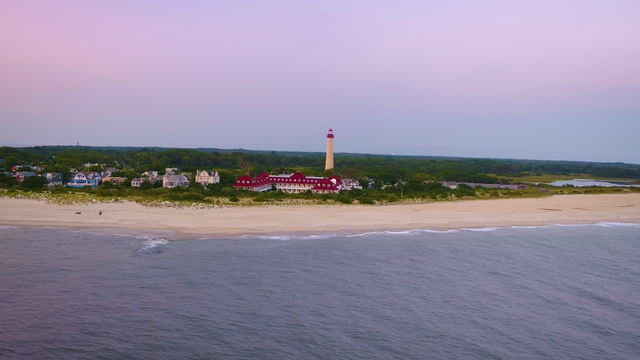 등대 주위로 해가 질 때 뉴저지 주 케이프 메이의 차분하고 선명한 4k 항공 영상