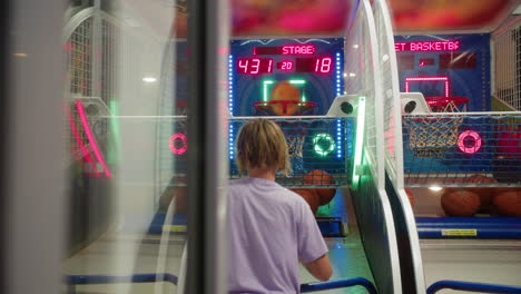 teen boy scoring in moving hoop at arcade