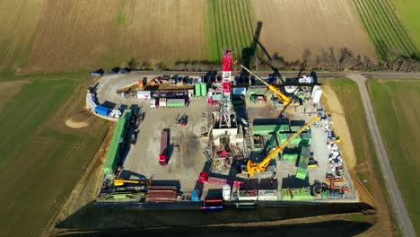 workers, cranes and equipment at the construction site of drilling rig in the field