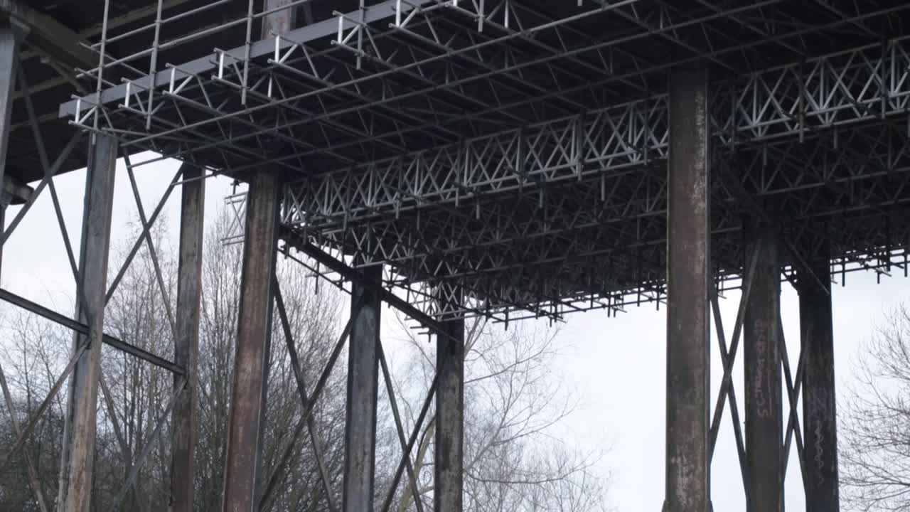 Old disused railway bridge abandoned and in decay tilting shot