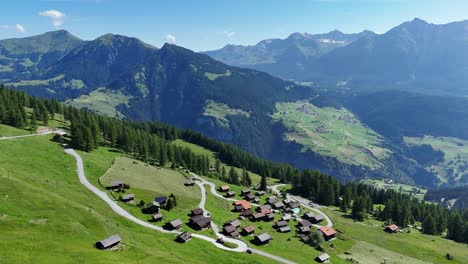 Aerial View of a Picturesque Alpine Village Nestled in a Green Mountain Valley