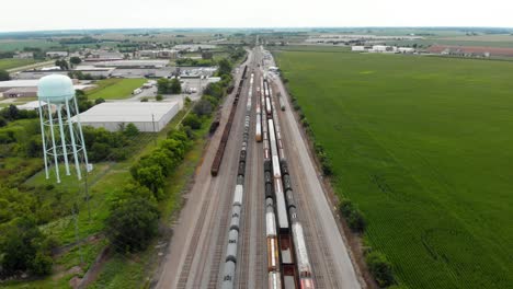 Vista-Aérea-De-4k-Que-Muestra-Varios-Trenes-Estacionados-En-Una-Estación-De-Tren-Esperando-Para-Salir